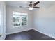 Neutral bedroom with a ceiling fan, dark hardwood floors, and a large window providing plenty of natural light at 2153 Pavilion Ct, Rock Hill, SC 29732