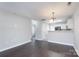 Open-concept view of a living room with dark floors, a view into the kitchen, and neutral walls at 2153 Pavilion Ct, Rock Hill, SC 29732