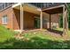 View of the home's brick exterior and covered patio with sliding glass doors, offering access to the backyard at 227 Country Club Cir, Shelby, NC 28150
