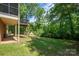 Expansive backyard featuring a lush lawn, mature trees, and a covered patio, perfect for outdoor entertaining at 227 Country Club Cir, Shelby, NC 28150