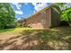 Exterior view of the brick home with a large yard, a back deck, and beautiful greenery at 227 Country Club Cir, Shelby, NC 28150