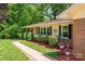 Brick ranch style house with beige vinyl siding, dark shutters and lush landscaping at 227 Country Club Cir, Shelby, NC 28150