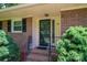 Close up of the brick ranch style house with dark shutters and landscaping at 227 Country Club Cir, Shelby, NC 28150