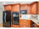 Kitchen showcasing wood cabinets, granite countertops, black appliances, and stainless steel accents at 227 Country Club Cir, Shelby, NC 28150