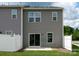 Gray home back exterior featuring sliding glass door, windows, and white privacy fence at 2448 Mariners Cove Ln, Denver, NC 28037