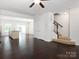 View of living room featuring dark wood floors, stairs and an entrance to the kitchen at 2448 Mariners Cove Ln, Denver, NC 28037