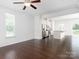 Spacious living room with dark wood floors and white walls leading to the kitchen at 2448 Mariners Cove Ln, Denver, NC 28037
