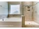 This bathroom offers a soaking tub next to a separate shower with neutral tile and a window at 2608 Wild Azalea Ct # 9, Monroe, NC 28110