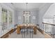 Stunning dining room featuring a wood table and crystal chandelier, filled with natural light from the large windows at 2906 Hillside Springs Dr, Charlotte, NC 28209