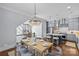 Elegant dining area with a wooden table, chandelier and stairs in view of a kitchen with stainless appliances at 2906 Hillside Springs Dr, Charlotte, NC 28209