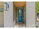 Charming front door with blue finish, brick surround, and stylish outdoor lighting fixture at 2906 Hillside Springs Dr, Charlotte, NC 28209