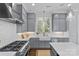 Well-lit kitchen featuring gray cabinets, stainless steel appliances, and a large farmhouse sink with white backsplash at 2906 Hillside Springs Dr, Charlotte, NC 28209