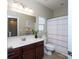 Well-lit bathroom featuring vanity with sink, mirror, toilet, and shower with a striped curtain at 3664 Privette Rd, Matthews, NC 28104