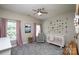 Sweet Bedroom with a white crib, soft pink accents, and a decorative flower wall hanging at 3664 Privette Rd, Matthews, NC 28104