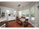 Bright dining area with a wooden table and chairs, surrounded by windows providing natural light and backyard views at 3664 Privette Rd, Matthews, NC 28104