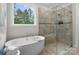 Bright bathroom featuring a soaking tub and glass shower, with a view of the outdoors at 3817 Arial Ln # 145, York, SC 29745