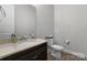 Bathroom featuring a dark vanity, toilet, large mirror, and essential fixtures in a well-lit space at 3817 Arial Ln # 145, York, SC 29745