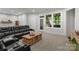 A large living room area featuring a black sofa, decorative items, and a door to the outside porch at 3817 Arial Ln # 145, York, SC 29745