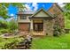 Beautiful backyard with stone patio, fire pit, lush greenery, and exterior view of home at 4339 Shannamara Dr, Matthews, NC 28104
