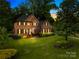Elegant brick home at twilight, featuring manicured landscaping and a striking blue front door at 4339 Shannamara Dr, Matthews, NC 28104