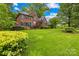 Charming two-story brick home with lush landscaping, a vibrant lawn, and a bright blue front door at 4339 Shannamara Dr, Matthews, NC 28104