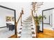 Elegant staircase with hardwood floors, white railings, and a large potted plant adding a touch of nature at 4339 Shannamara Dr, Matthews, NC 28104