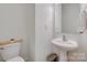 This half bathroom features a pedestal sink, toilet and neutral tones at 461 Hurston Cir # 51, Charlotte, NC 28208