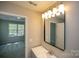 Bright bathroom featuring vanity with faucet, framed mirror, and view to the bedroom at 4938 Sunset Ridge Ct, Charlotte, NC 28269