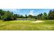 Scenic golf course view with a small pond and players, set against a clear sky at 4938 Sunset Ridge Ct, Charlotte, NC 28269