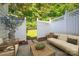 Cozy patio area with outdoor seating, a wooden coffee table, and a white privacy fence at 4938 Sunset Ridge Ct, Charlotte, NC 28269