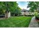 Well-maintained exterior of a condo building with lush green lawn and mature trees at 5009 Sharon Rd # E, Charlotte, NC 28210
