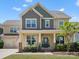 Inviting two-story home featuring a covered porch, manicured lawn, and charming curb appeal on a sunny day at 5013 Hamilton Mill Dr, Waxhaw, NC 28173
