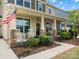 Inviting front porch with rocking chairs, lush landscaping, American flag and beautiful columns at 5013 Hamilton Mill Dr, Waxhaw, NC 28173