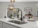 Kitchen island with sink, modern faucet, and decorative pendant lighting above at 5013 Hamilton Mill Dr, Waxhaw, NC 28173