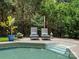 Relaxing poolside lounge area with two chairs, string lights, and lush greenery for ultimate outdoor enjoyment at 5013 Hamilton Mill Dr, Waxhaw, NC 28173