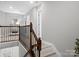 Hallway with wooden staircase and iron railing leading to the second floor at 5013 Hamilton Mill Dr, Waxhaw, NC 28173