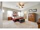 Bright bedroom with neutral tones features a ceiling fan, ensuite bath, and ample closet space at 5025 Kinross Ln, Indian Land, SC 29707