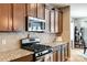 Close-up of the kitchen showing stainless steel appliances, tile backsplash, and granite countertops at 5025 Kinross Ln, Indian Land, SC 29707