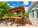 Outdoor patio with a wooden pergola offering shaded seating and a dining area, perfect for entertaining at 5025 Kinross Ln, Indian Land, SC 29707