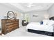 Bright bedroom featuring a tray ceiling, neutral walls, a wood dresser, and an inviting accent chair by the window at 516 Aspen Ln, Indian Trail, NC 28079