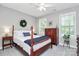 Bright bedroom featuring a four-poster bed, a bedside table, a dresser, and two large windows at 516 Aspen Ln, Indian Trail, NC 28079