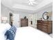 Well-lit bedroom with a tray ceiling, a dresser, a window, and an open doorway to a bathroom at 516 Aspen Ln, Indian Trail, NC 28079