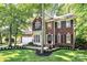Charming brick two-story home with a well-manicured lawn and mature trees at 516 Aspen Ln, Indian Trail, NC 28079