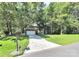 Traditional brick home featuring a long driveway, large front lawn, mature trees, and a two-car garage at 516 Aspen Ln, Indian Trail, NC 28079