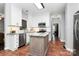 Well-lit kitchen boasting white cabinets, stainless steel appliances, and stylish backsplash at 516 Aspen Ln, Indian Trail, NC 28079