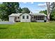 A spacious backyard with well-maintained lawn and screened in porch at 5428 Barnsdale Ln, Mint Hill, NC 28227