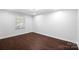 Simple bedroom featuring hardwood floors and natural light from the large window at 5428 Barnsdale Ln, Mint Hill, NC 28227