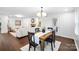 Bright dining area featuring modern lighting, leading to a cozy living room with fireplace at 5428 Barnsdale Ln, Mint Hill, NC 28227