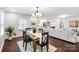 Open-concept living area with dining table, modern lighting, and view into the living room at 5428 Barnsdale Ln, Mint Hill, NC 28227