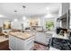 Well-lit kitchen featuring an island with granite countertop, stainless steel appliances, and an open view to the living room at 5428 Barnsdale Ln, Mint Hill, NC 28227
